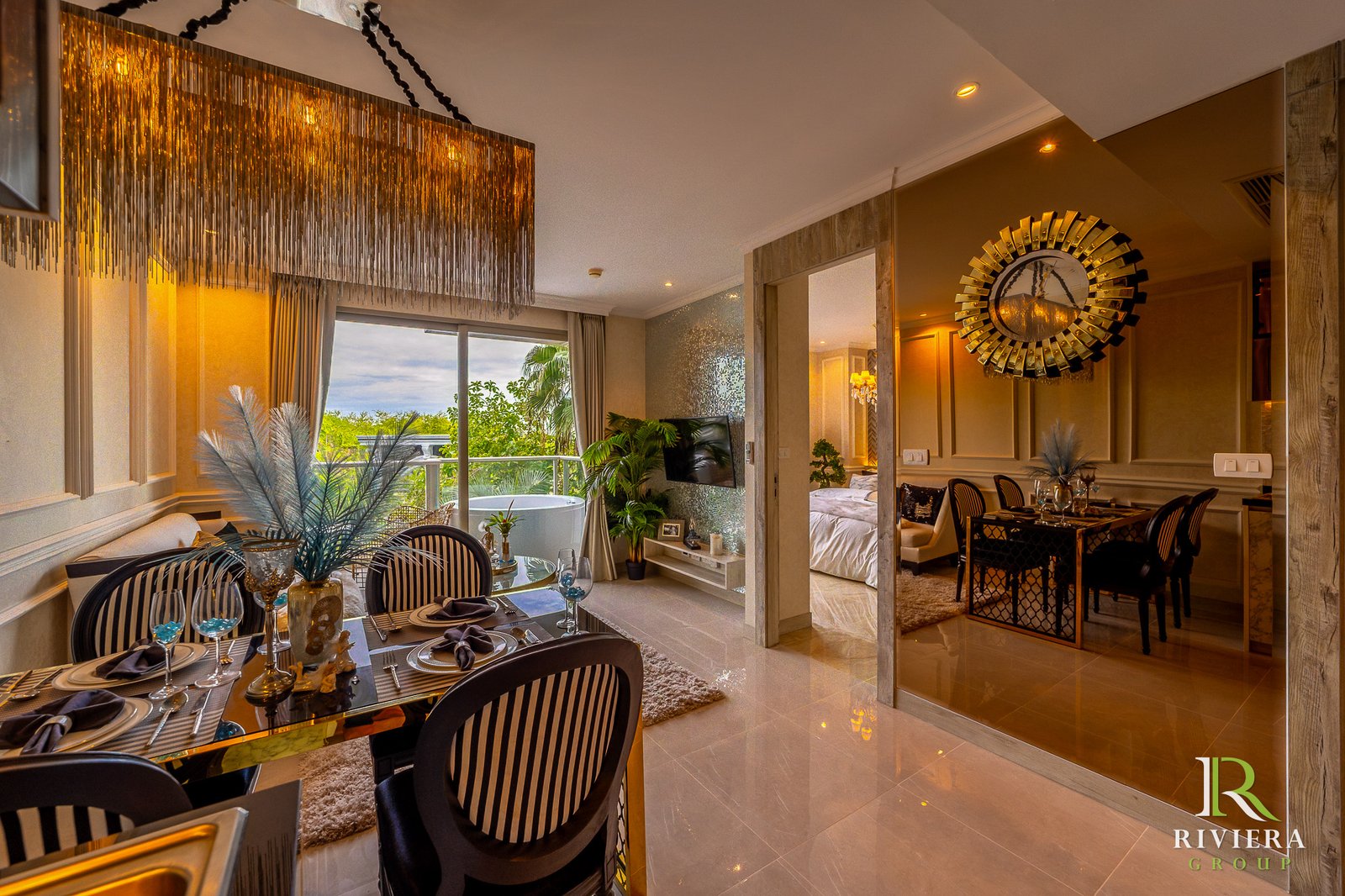 302-S04 Elegant dining area with a glass table set for a meal, black striped chairs, and gold-toned chandelier, overlooking a balcony garden.