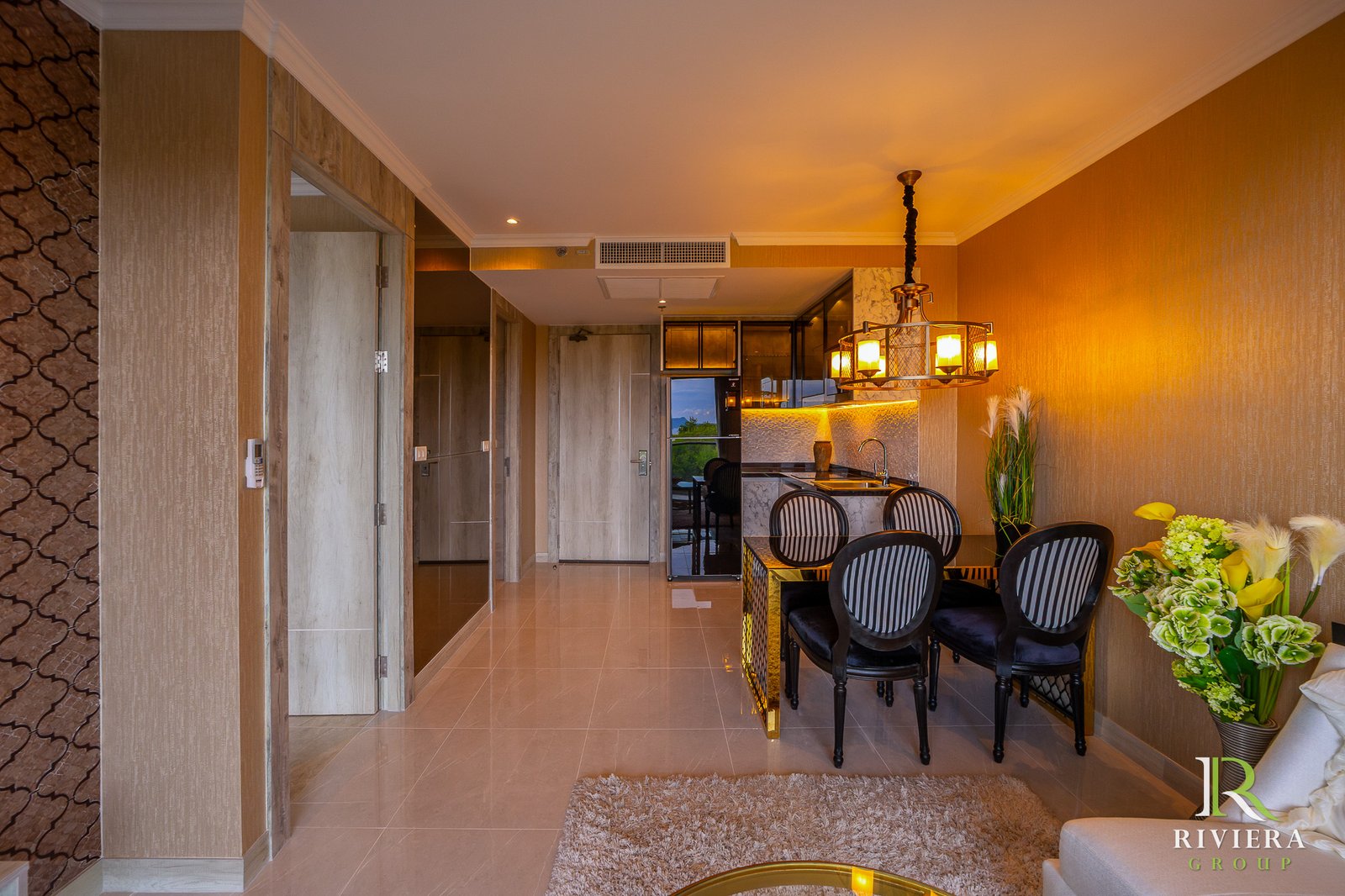502-S09 Open-plan dining area with a kitchen island, chandelier, and orange textured walls.