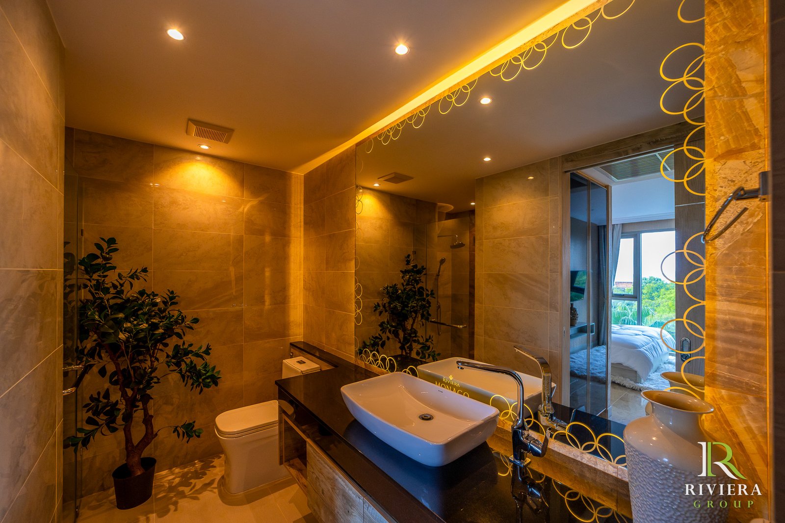 502-S14 Luxurious marble bathroom with double sinks, a backlit circle-pattern mirror, and potted plants.