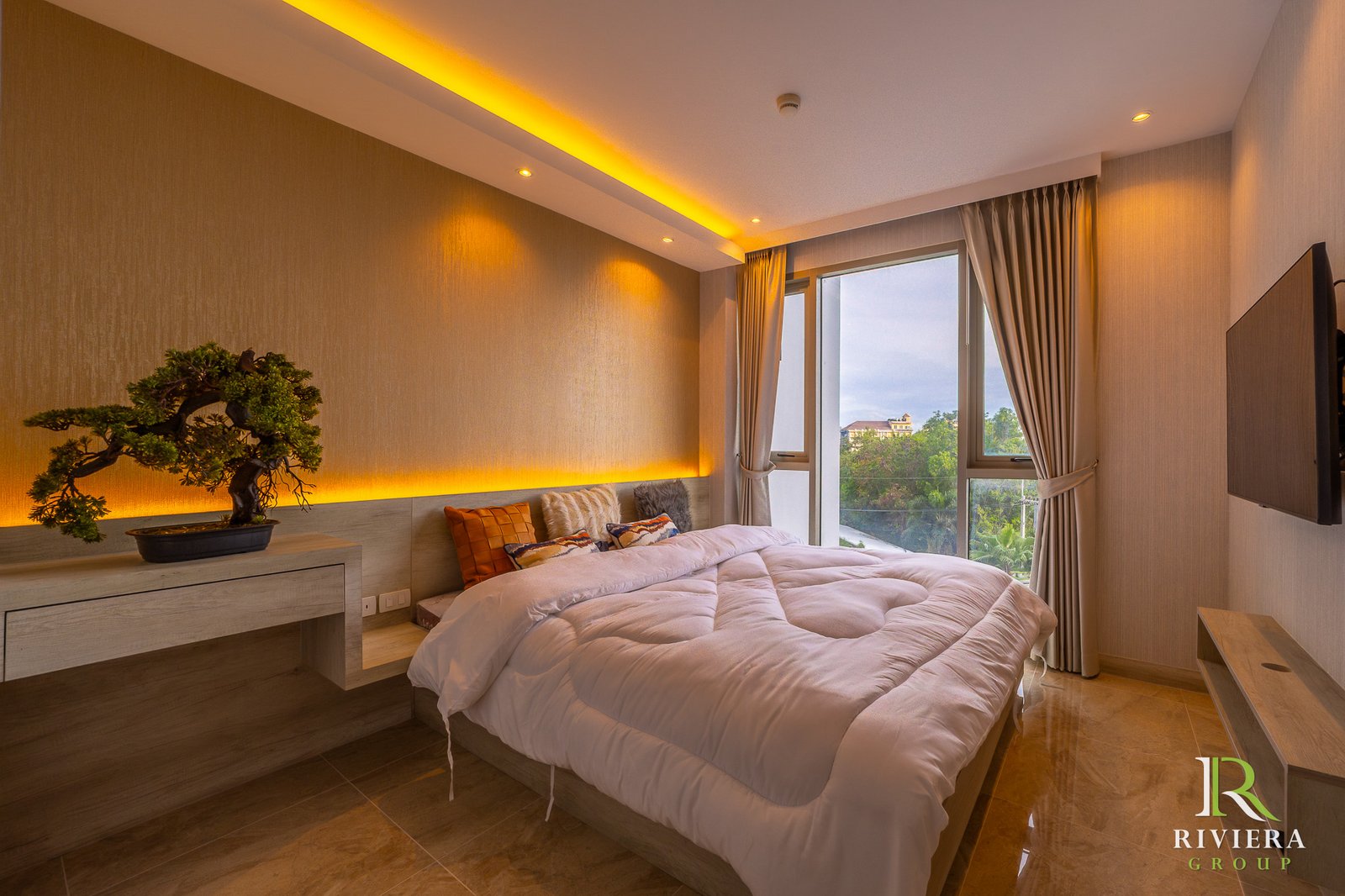 505-S08 Hotel bedroom with two white comforter beds, warm amber lighting, and a large window with beige curtains; a bonsai sits on a desk near the wall.