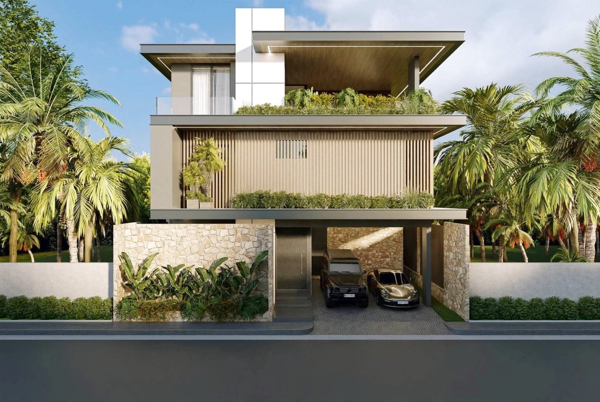 Front view of a modern, three-story house with white and wood facade, glass balcony, and a two-car garage amid tropical landscaping.