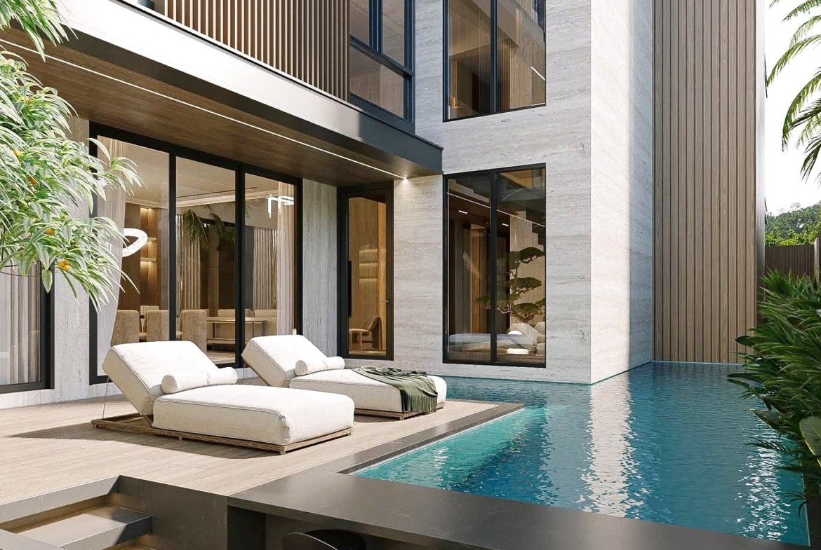 Modern house exterior with glass walls, wood slats, and a poolside deck with white lounge chairs by the water.