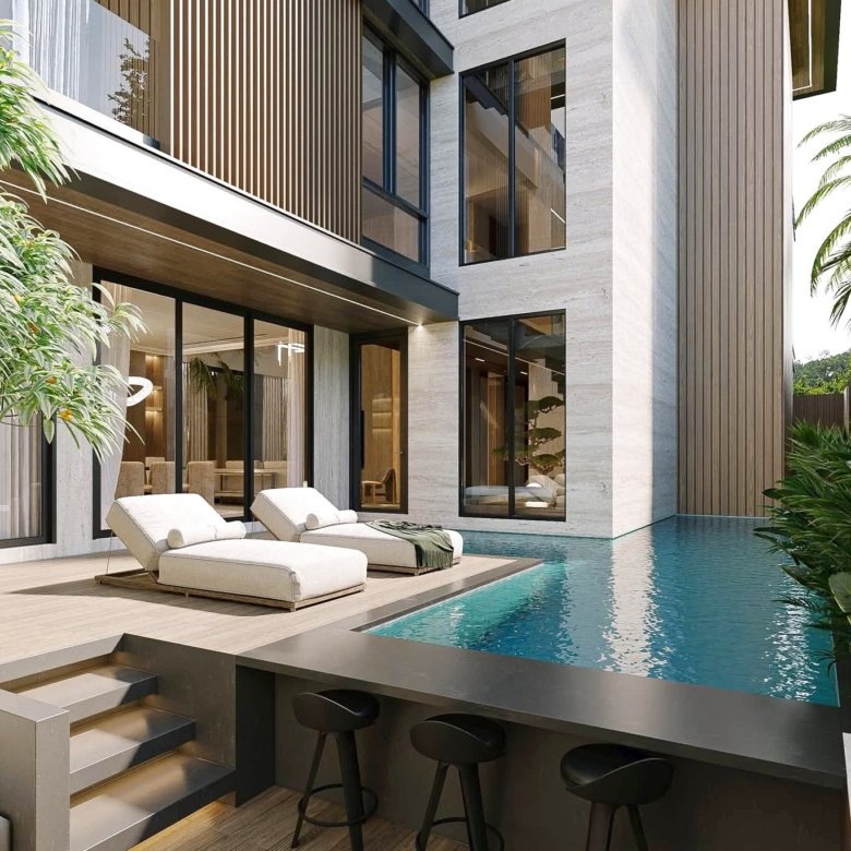 Modern house exterior with glass walls wood slats and a poolside deck with white lounge chairs by the water