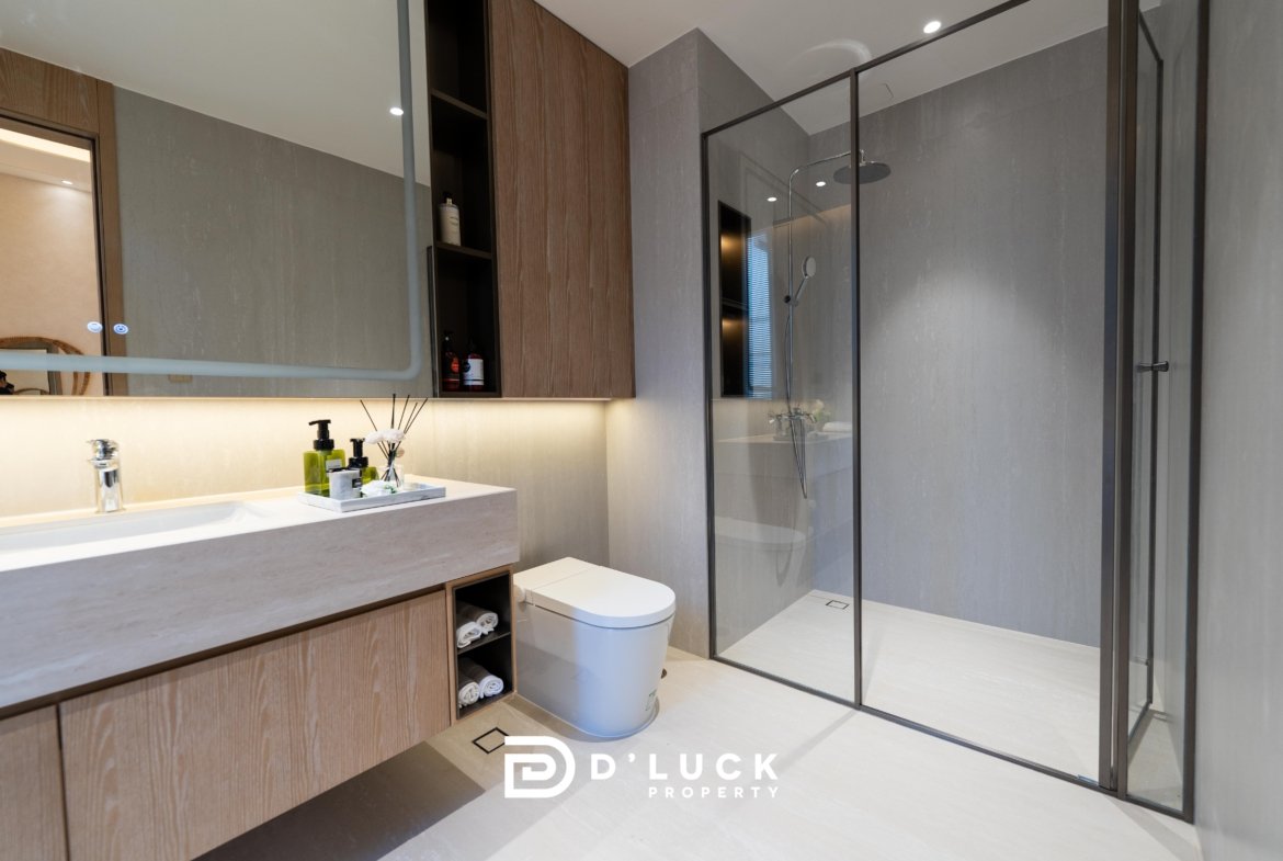 Modern bathroom with a wooden vanity, open storage shelves, and a glass-walled shower enclosure.
