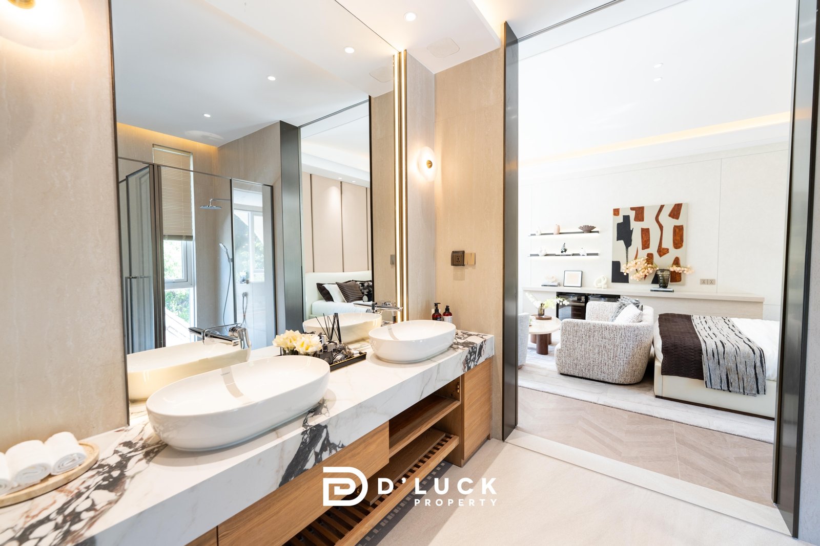 Big_V_Pattaya_Type_A_36 Luxurious bathroom vanity with two round vessel sinks on a marble countertop, mirrored walls, and wood shelving, opening to a stylish living area.
