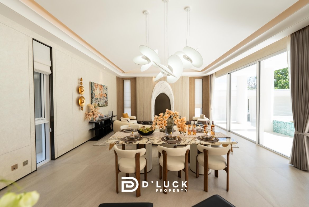 Modern dining room with a sculptural white chandelier, marble table set for a meal, and large windows bringing in natural light.