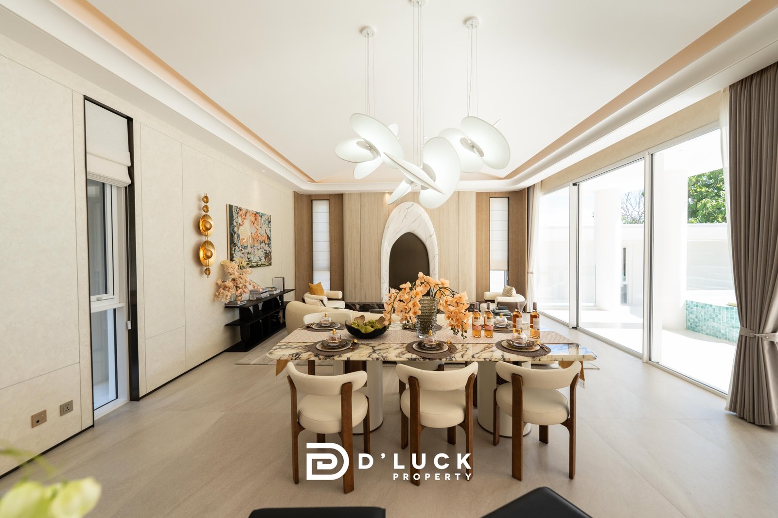 Big_V_Pattaya_Type_A_68 Modern dining room with a sculptural white chandelier, marble table set for a meal, and large windows bringing in natural light.