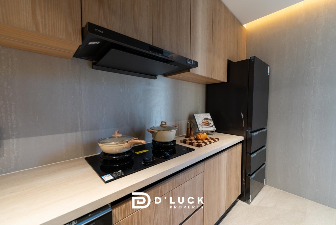 Modern kitchen with a black induction cooktop, two pots, and wooden cabinets above and below the counter.