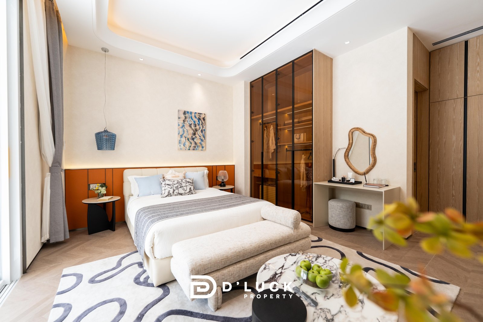Big_V_Pattaya_Type_A_85 Luxurious bedroom with a white bed, orange headboard, and blue-gray pillows in a bright modern suite.