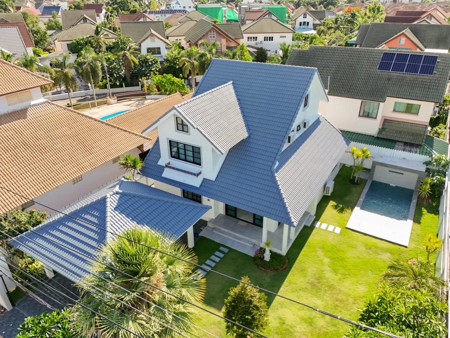Central_Park_5_Pattaya_Sale_Dlh506 Aerial view of a white two-story house with a blue tile roof and manicured front yard.
