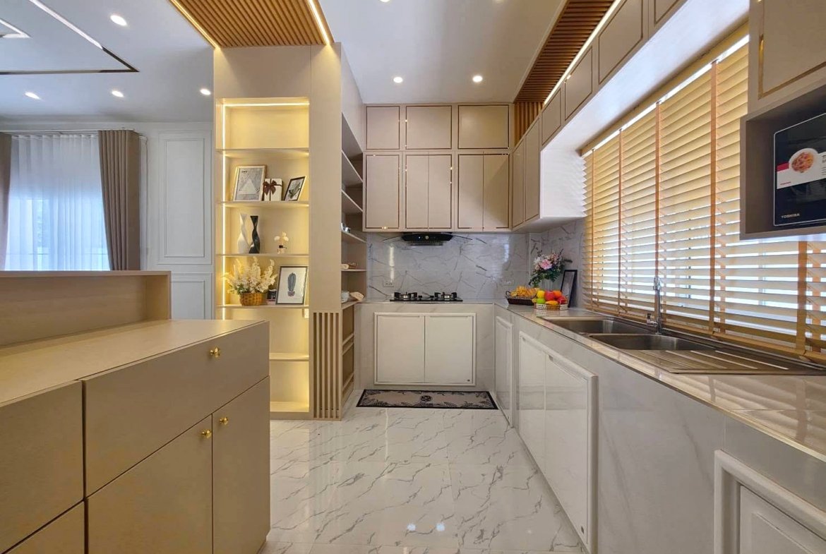 Bright modern kitchen with cream cabinets, marble floor, and large window with wooden blinds