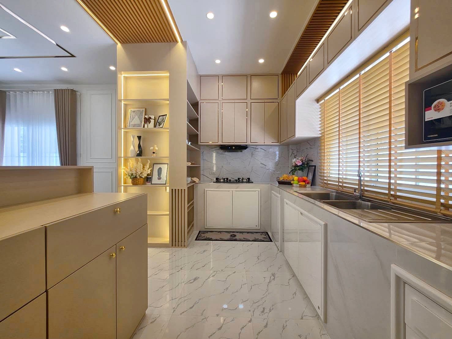 Bright modern kitchen with cream cabinets, marble floor, and large window with wooden blinds