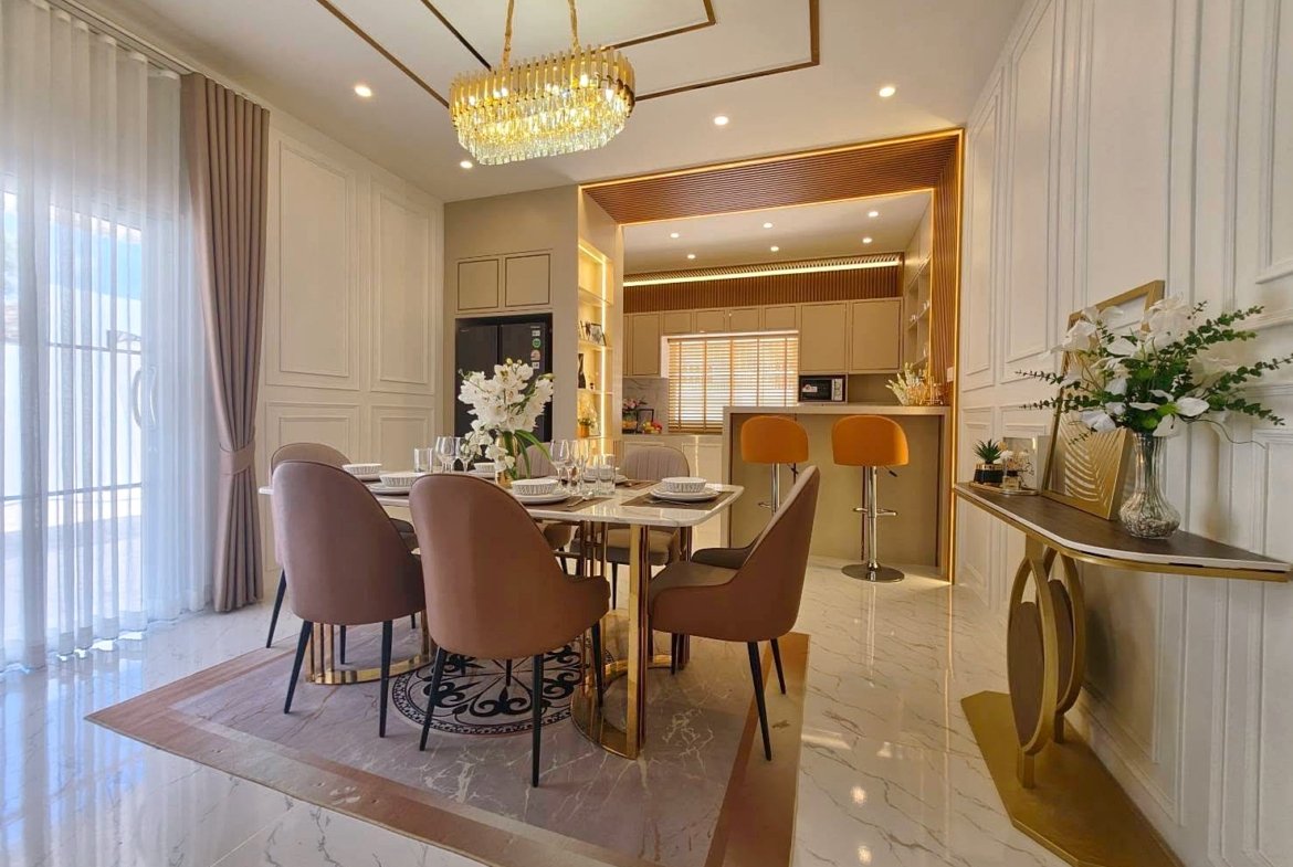 Luxurious dining room with a marble floor, blush chairs, and a gold chandelier over a modern table set for six.