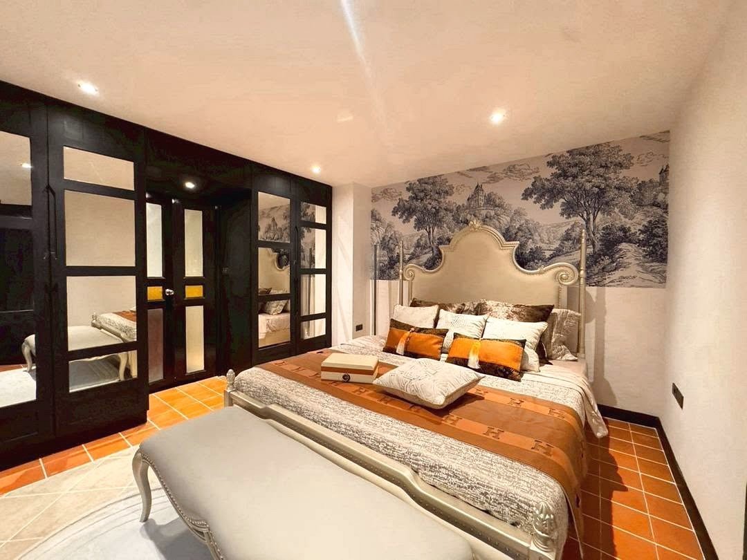 Dharawadi_Poolvilla_Rent_Rdl353_21 Luxurious bedroom with an ornate upholstered bed, black-framed wardrobes, and a tree mural wall behind the headboard.