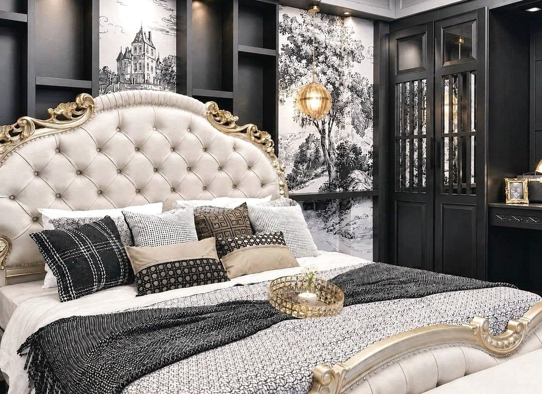 Luxurious bedroom with a tufted beige headboard, gold detailing, and a patterned black-white bedding set with multiple throw pillows.