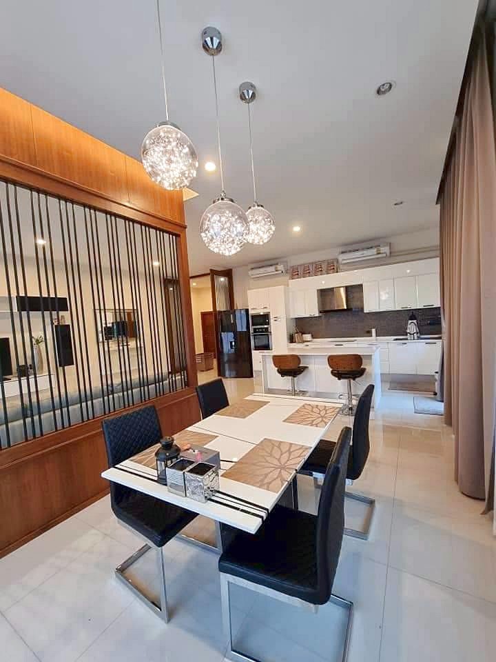Garden_Ville_1_Pattaya_Rent_Rdl368_5 Modern dining area with glass pendant lights above a white striped table and black chairs, open kitchen in back.