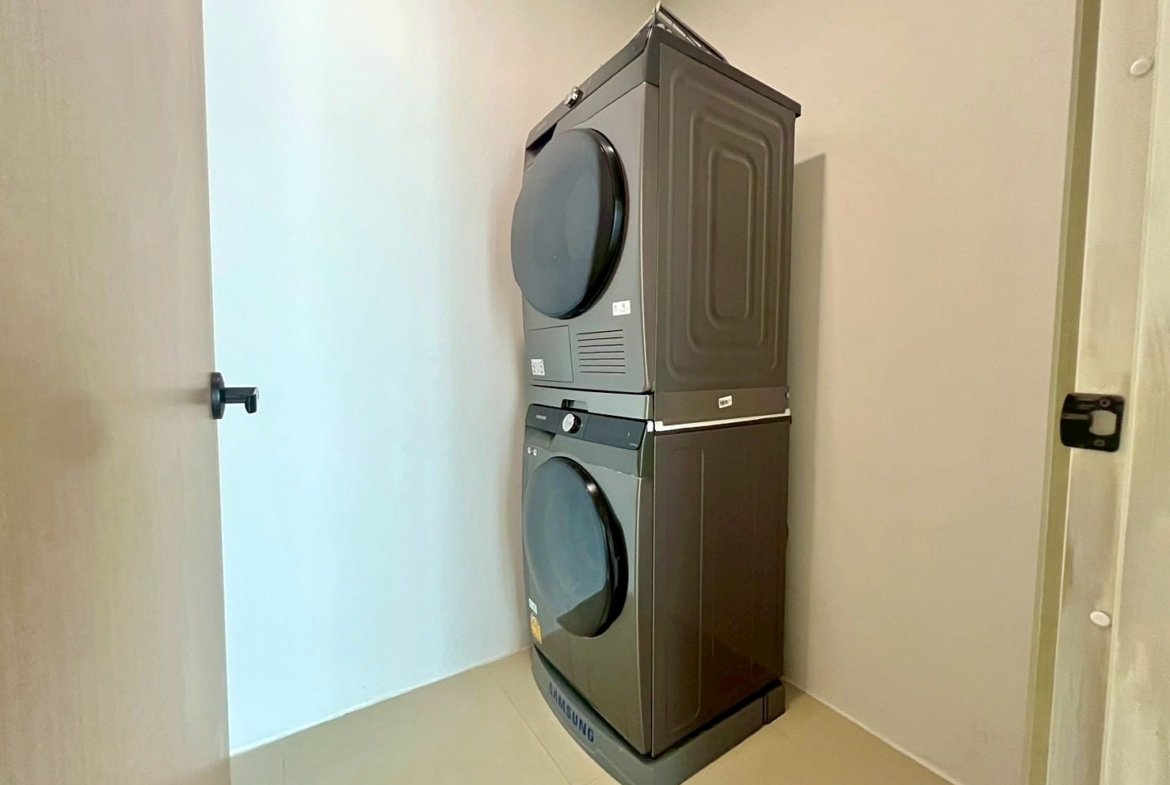 Stacked front-loading washer and dryer in a small laundry closet.