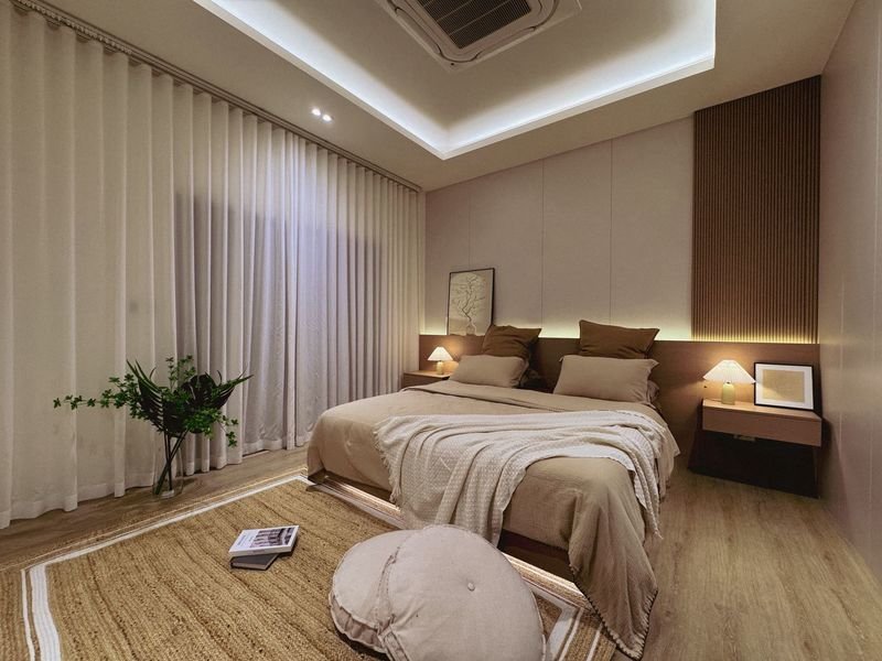 Modern beige bedroom with a queen bed, two nightstands with lamps, and a plant by sheer curtains.