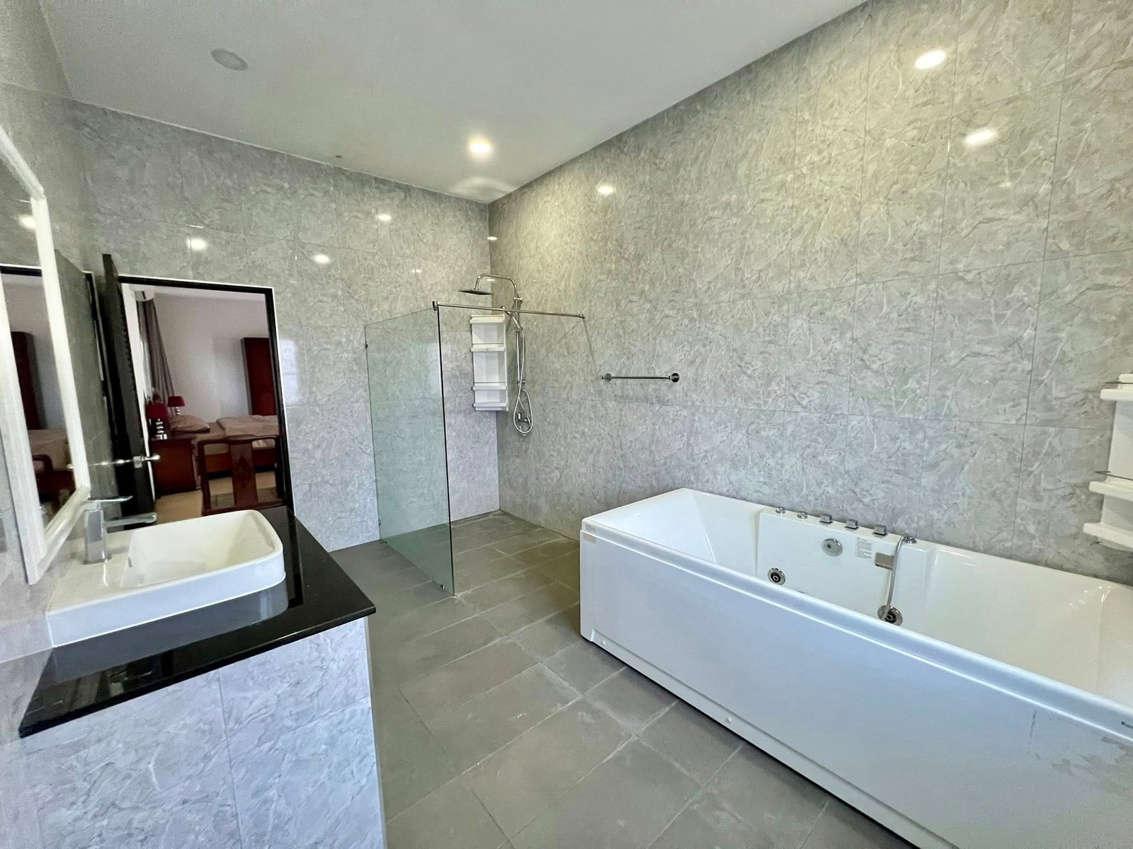 House_Sale_Mabprachan_Pattaya_Dlh533_22 Modern bathroom with grey marble walls, glass shower enclosure, and white bathtub.