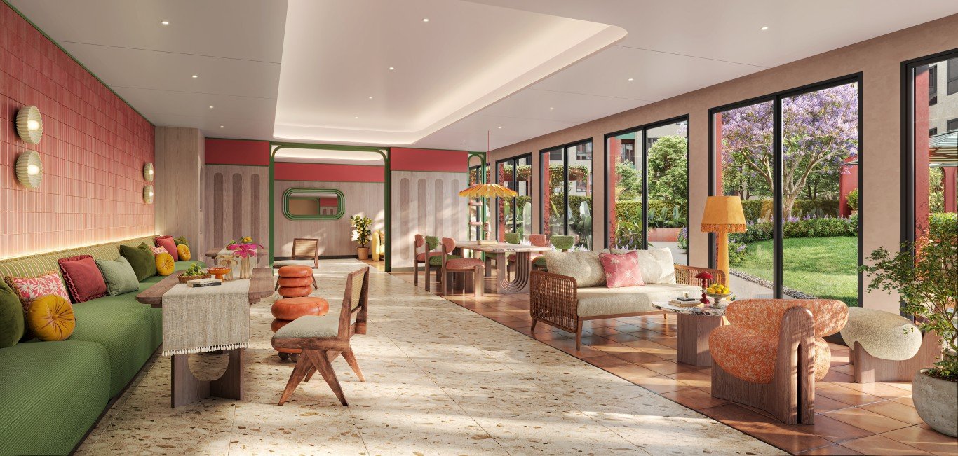 INT_LOBBY_FINAL Bright, inviting lounge with a green sofa and colorful cushions beside large windows that overlook a garden.