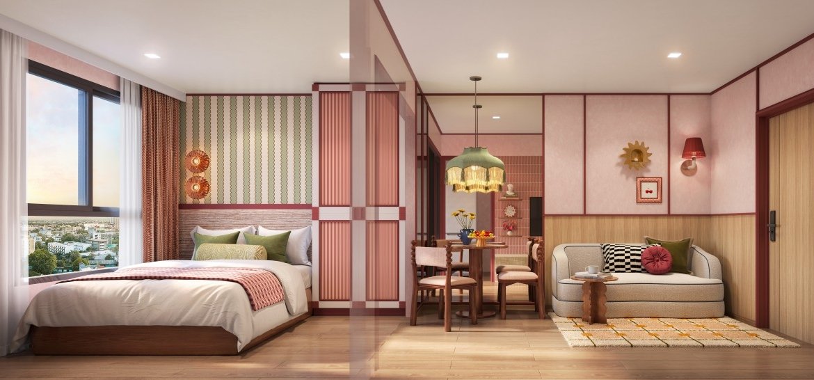 Spacious hotel suite with a king bed on the left, a round dining table in the center, and a beige sofa on the right, pink wood paneling throughout. (city view through window)