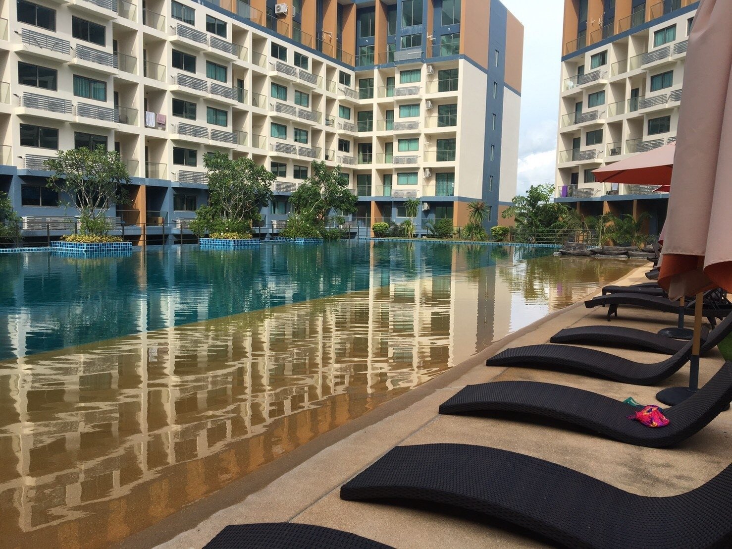 Laguna_Beach_Resort_2 35 Outdoor hotel pool area with modern low-rise buildings, lounge chairs, and umbrellas along the pool deck.