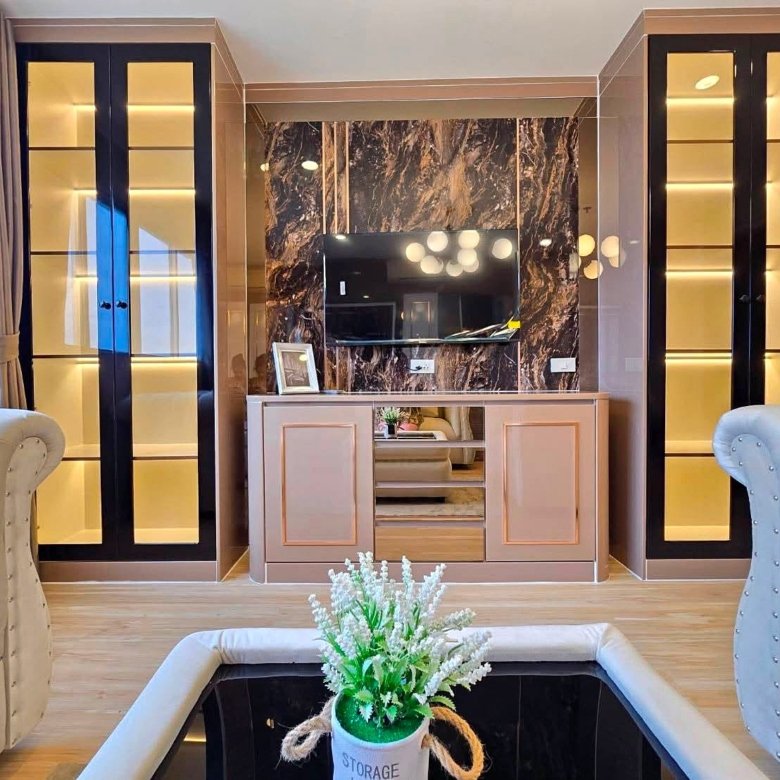 Luxurious living room with a marble feature wall wall mounted TV and beige storage cabinet flanked by tall glass display cabinets