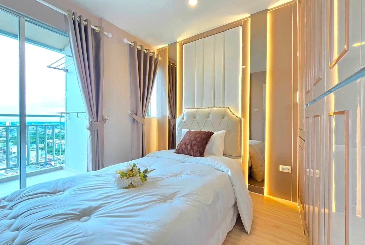 Luxurious white tufted bed in a bright modern bedroom with gold LED trim and mirrored wardrobe panels.