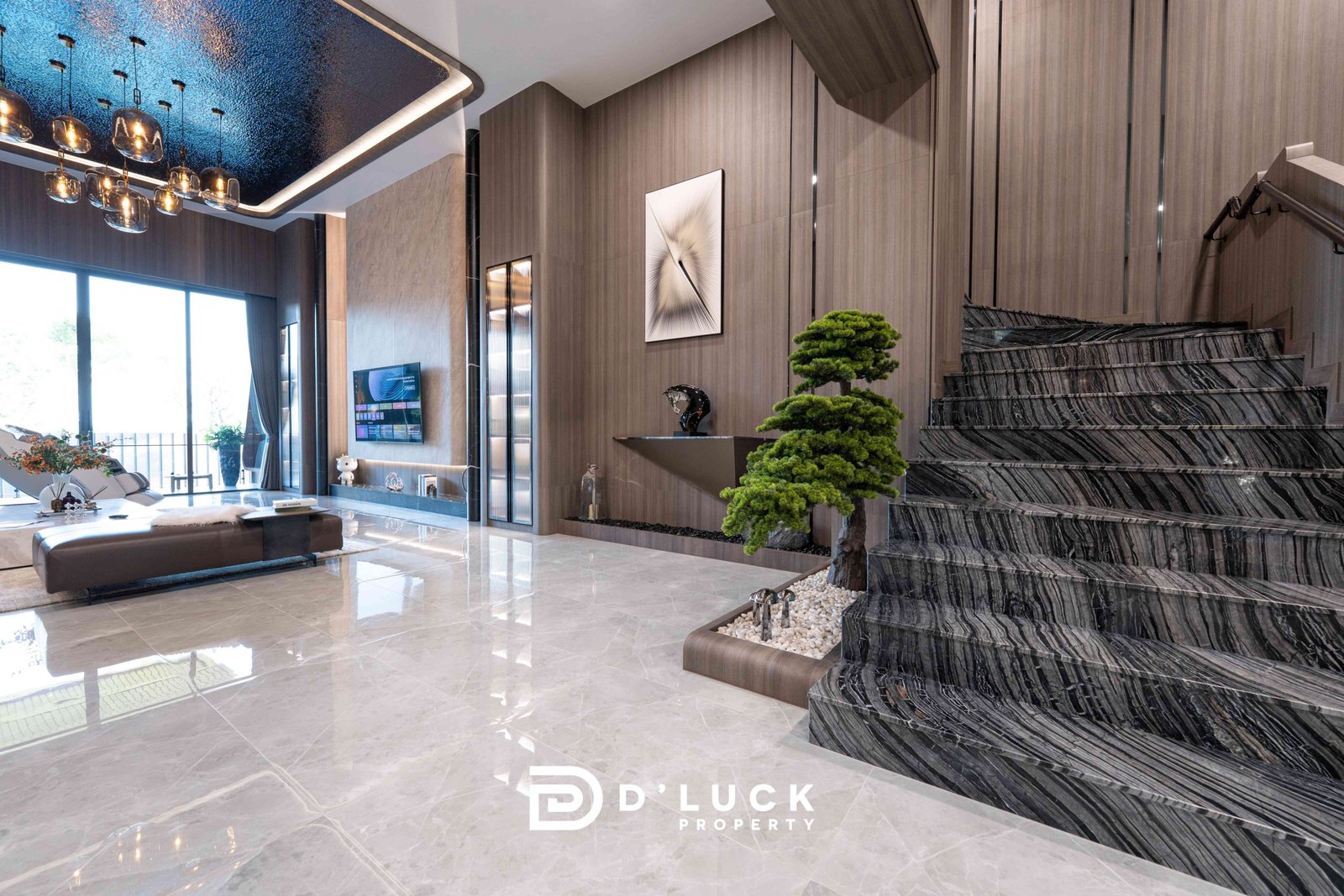 M-Mountian-M3 103 Contemporary living space with marble floors, a dramatic dark marble staircase, wall paneling, and a bonsai tree near a glass wall.