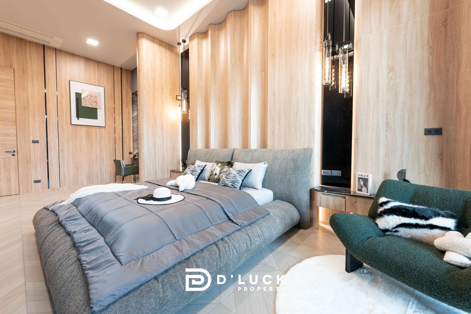 M-Mountian-M3 87 Luxurious bedroom with wood-paneled walls, gray upholstered bed, and green chairs; hat on bed and Vogue magazine on the nightstand.