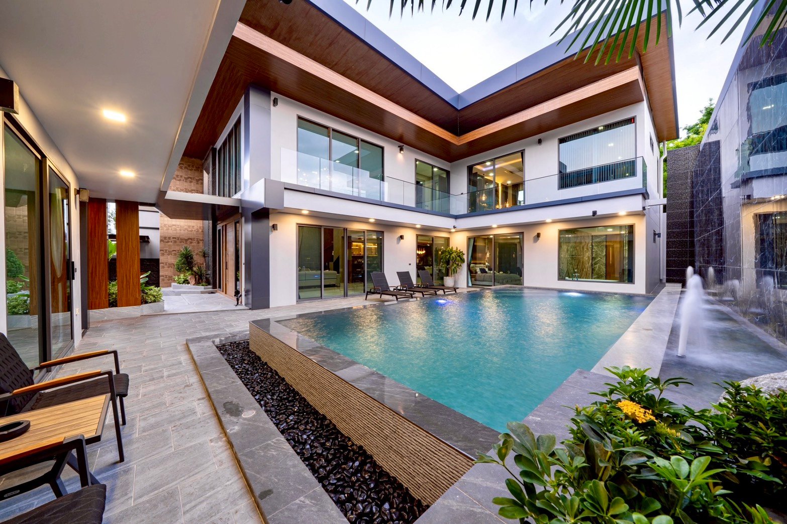 M_Mountain_Dlh518 14 Modern two-story villa surrounding a rectangular pool; glass railings, lounge chairs, and sliding doors on courtyard level.