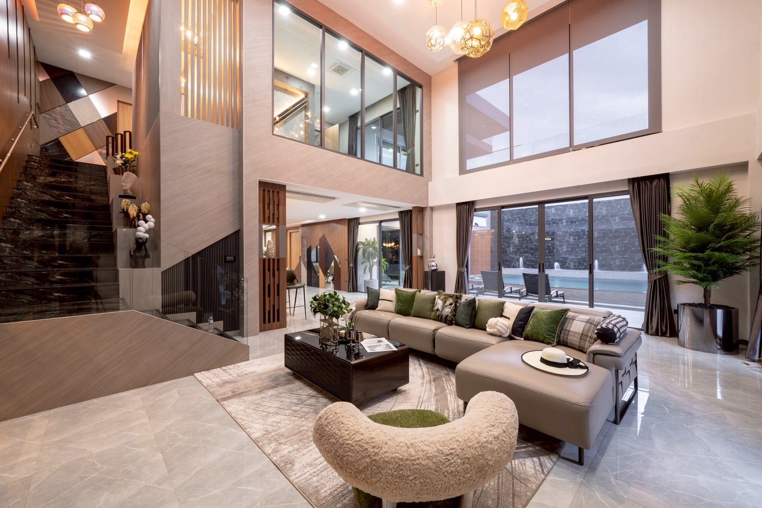M_Mountain_Dlh518 18 Luxurious living room with L-shaped sofa, green cushions, and a glass coffee table facing floor-to-ceiling windows overlooking a pool.