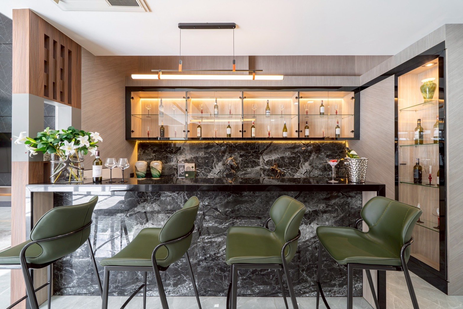 M_Mountain_Dlh518 21 Modern home bar with a black marble counter, glass-front cabinets, and green bar stools.