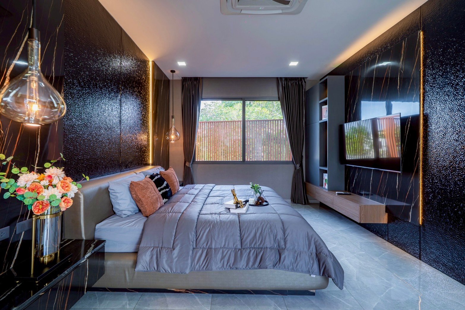 M_Mountain_Dlh518 37 Luxurious modern bedroom with a large gray bed, velvet pillows, and glossy black marble walls with gold veining.