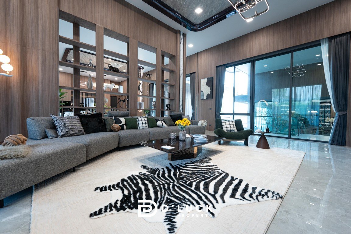 Contemporary living room with a long gray sectional, glass coffee table, and a zebra rug.