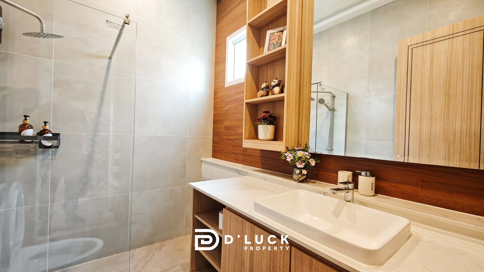 Modern bathroom featuring a glass shower enclosure, light gray tiled walls, and a white marble countertop with a rectangular sink.