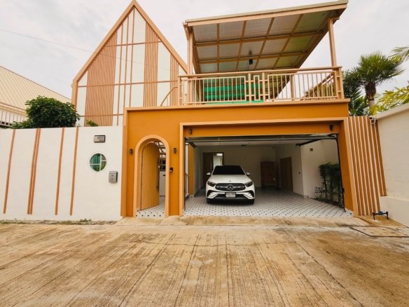 White Mercedes SUV parked in a covered carport of a modern orange-yellow house with striped walls and a circular window on the left.