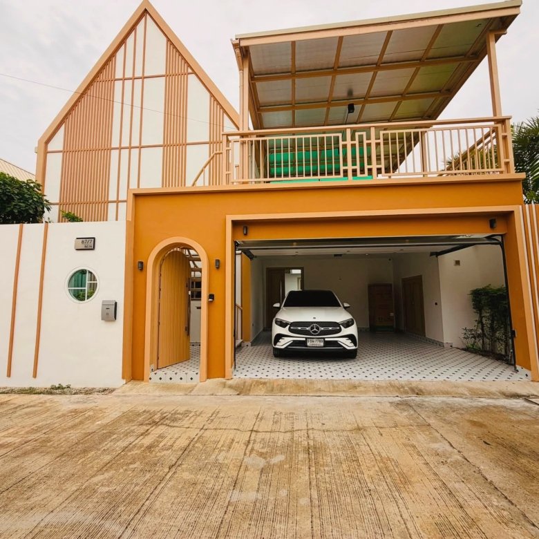 White Mercedes SUV parked in a covered carport of a modern orange yellow house with striped walls and a circular window on the left