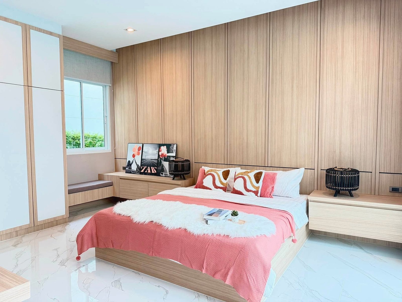 Narita_Villa_Pattaya_Rent_Rdl339_12 Modern bedroom with light wood paneling, platform bed in pink bedding and white fur throw, matching nightstands on each side