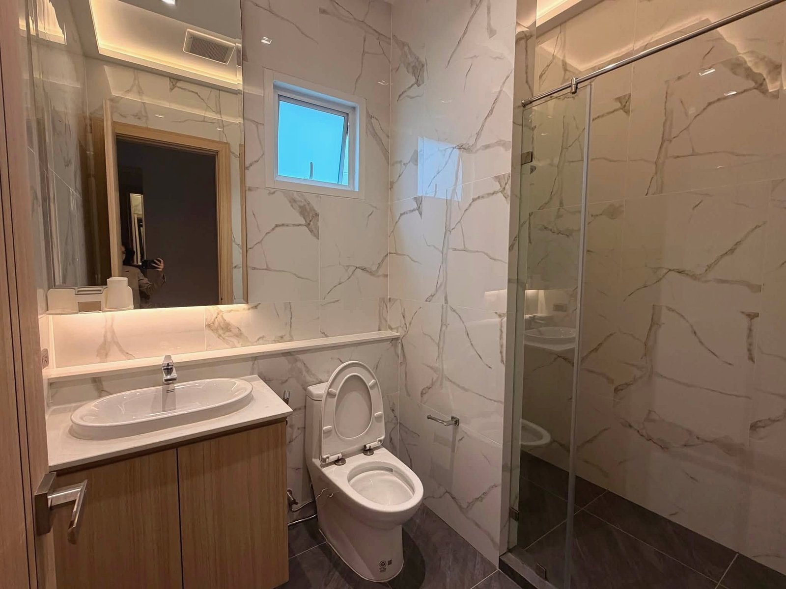 Narita_Villa_Pattaya_Rent_Rdl339_15 Marble-tiled bathroom with a wood vanity, oval sink, and glass shower enclosure
