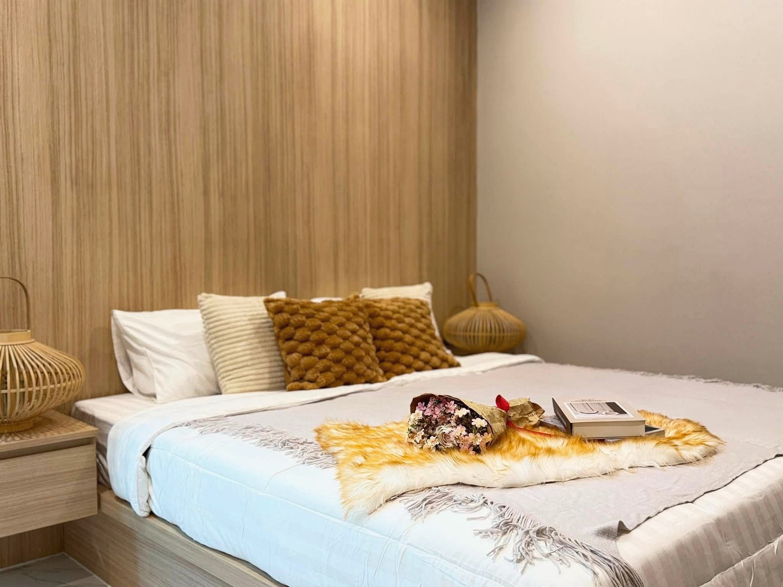 Narita_Villa_Pattaya_Rent_Rdl339_6 Two neatly made twin beds in a cozy bedroom with beige pillows, a wooden paneled wall, and wicker lamps on each side.