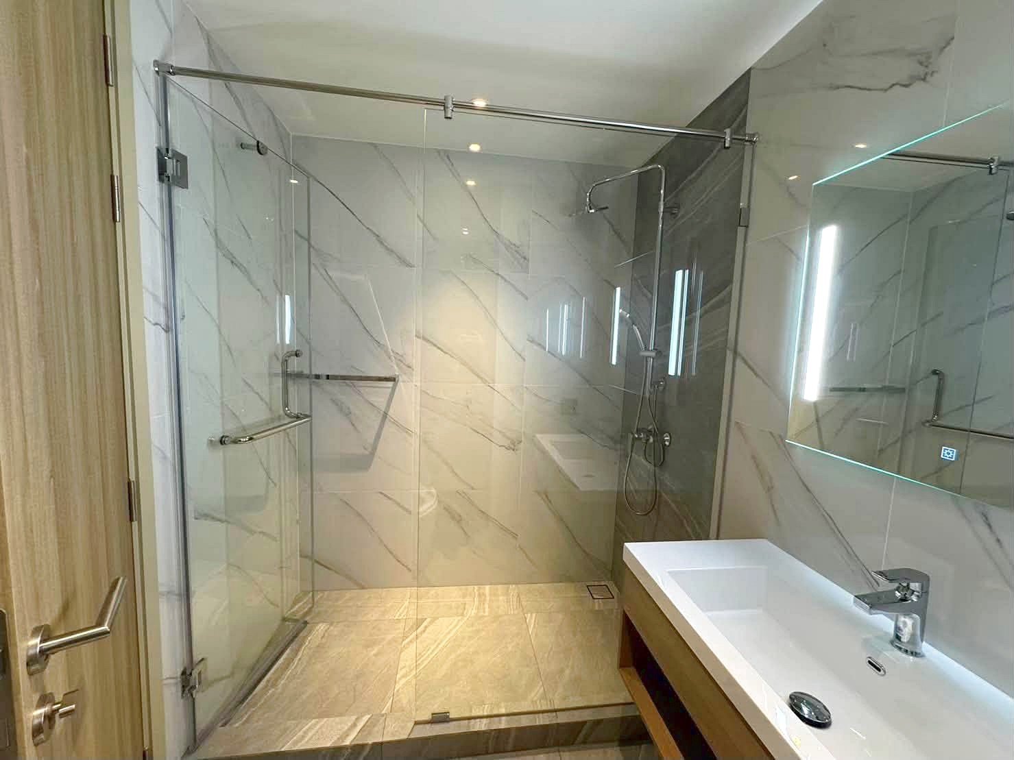 Once_Pattaya_Rent_Rdl366_5 Modern bathroom with glass-walled shower, marble walls, and a white rectangular sink