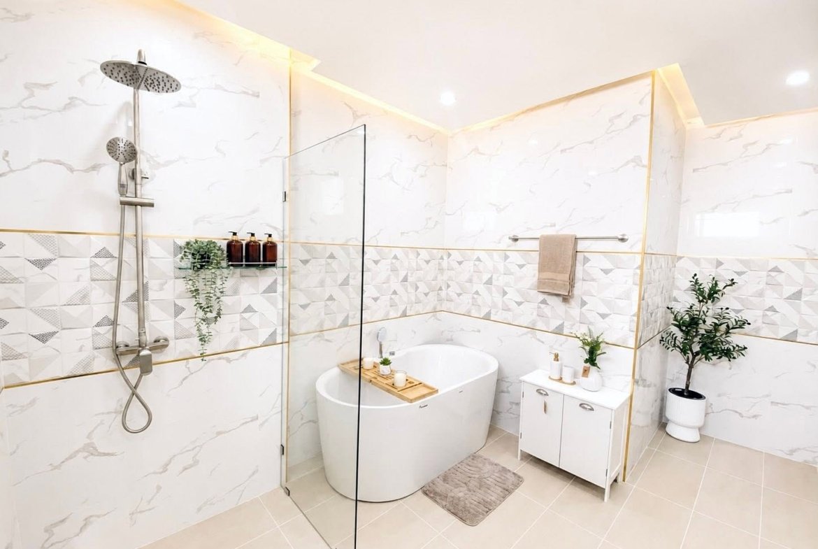 Modern spa-style bathroom with a freestanding white tub, glass divider, and a rainfall shower on the left; geometric tile accent and marble walls brighten the space.
