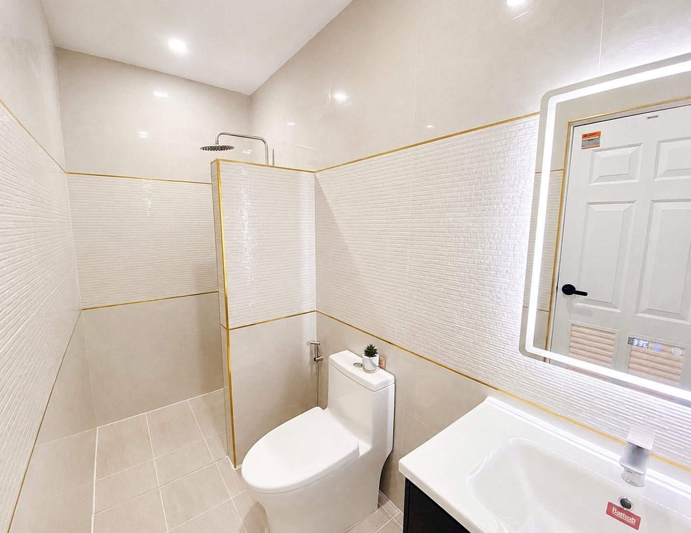 Small modern bathroom with a walk-in shower, white toilet, and sink with a backlit mirror on the wall.