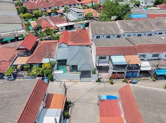 Aerial view of a dense residential neighborhood with red-tiled roofs and narrow streets.