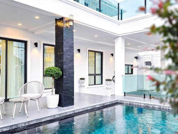 Modern poolside patio with white walls black stone pillar glass doors and outdoor seating by the pool