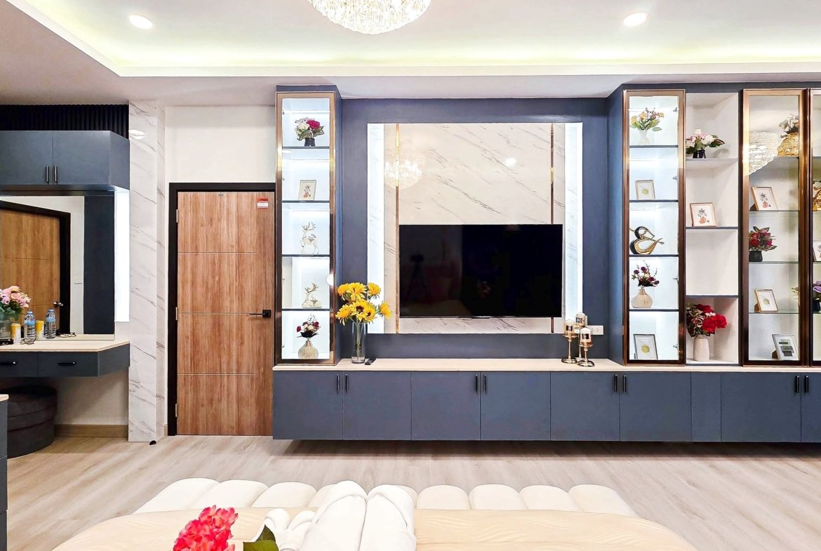 Modern living room built-in unit with a wall-mounted TV, glass display cabinets, and blue-gray cabinetry with marble accents.
