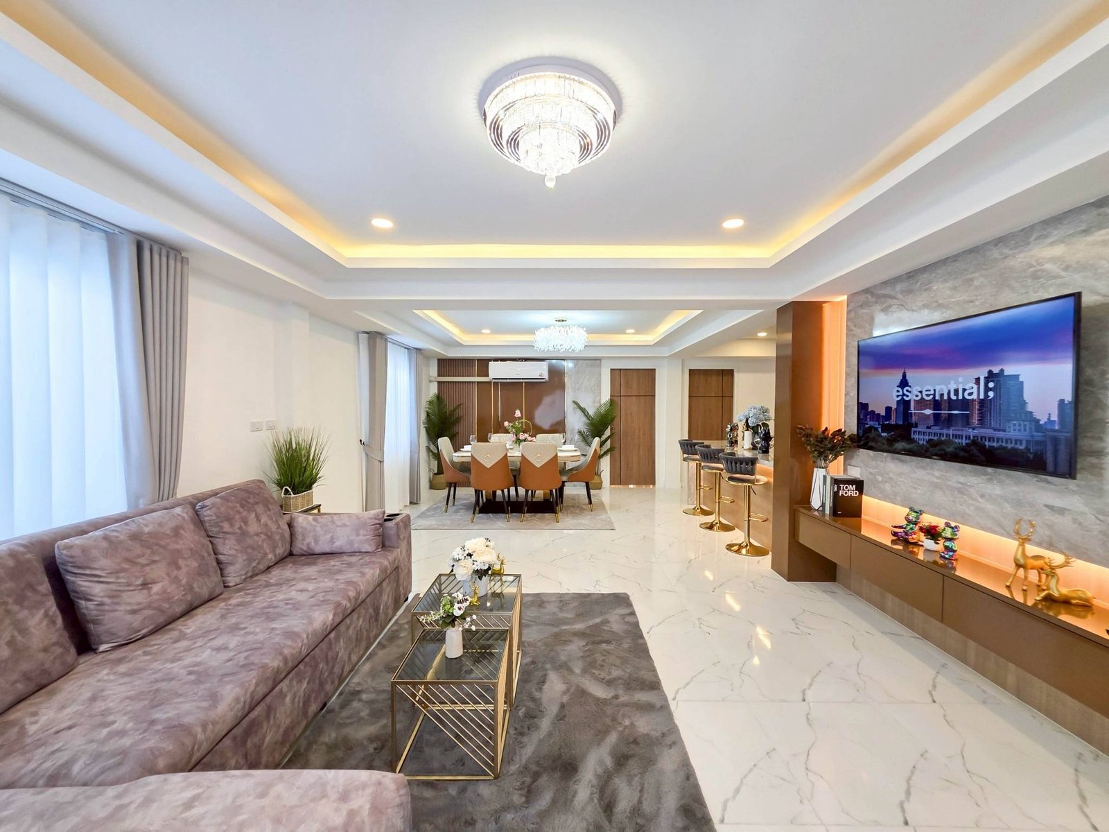 Pool_Villa_South_Pattaya_Sale_Dlh498_10 Modern open-plan living and dining room with a purple sofa, glass tables, and a crystal chandelier.
