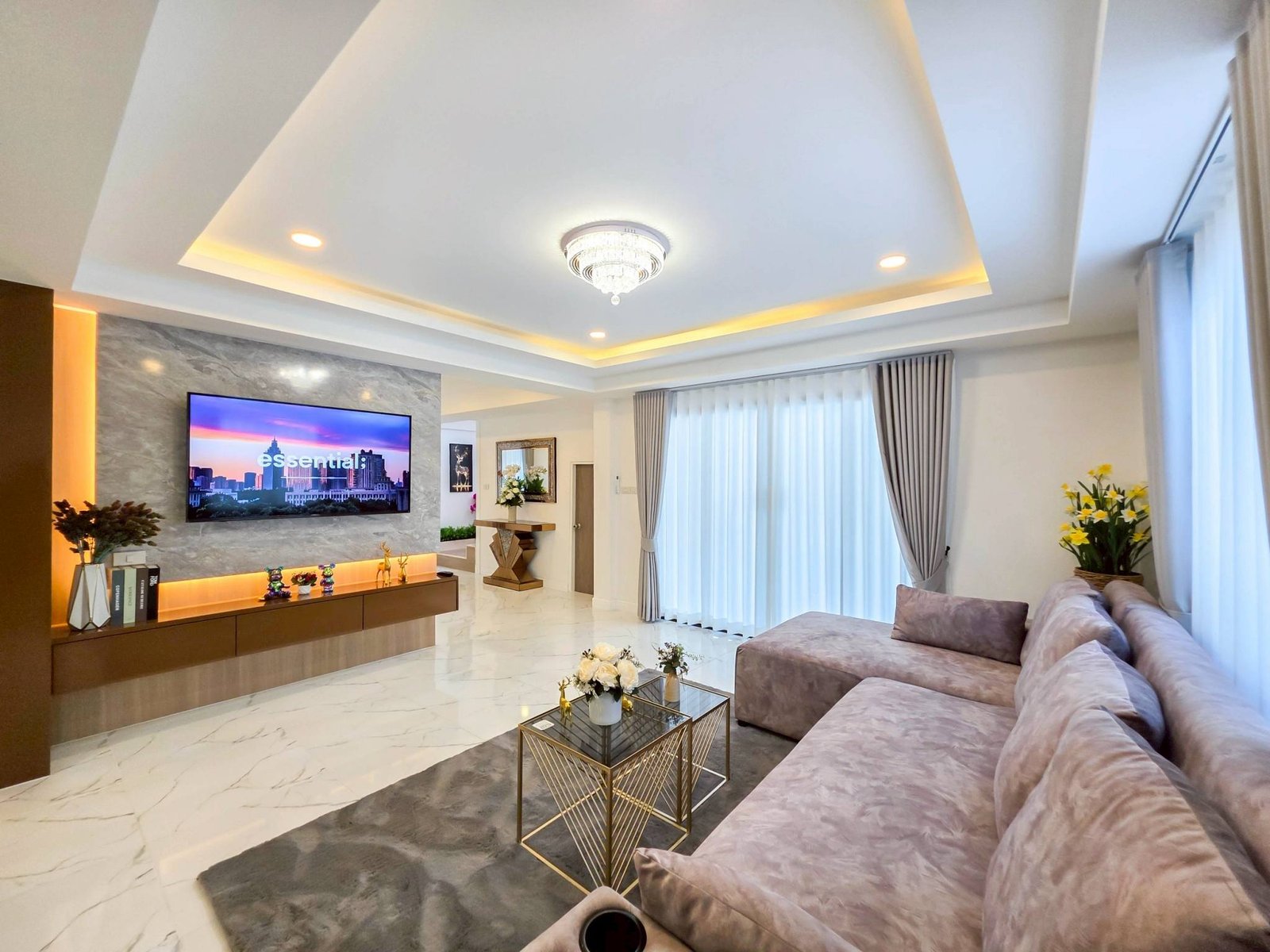 Pool_Villa_South_Pattaya_Sale_Dlh498_3 Luxurious living room with marble floors, beige sofa, glass coffee tables, and a crystal chandelier centerpiece.