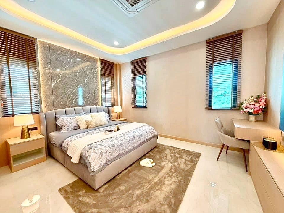Luxurious modern bedroom with a grey upholstered bed, marble feature wall, and matching nightstands with lamps.